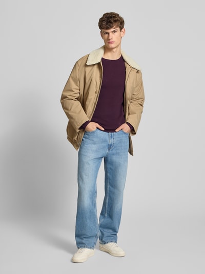 Männermodel trägt Basic Strickpullover mit Rundhalsausschnitt und Rollkanten von REVIEW in Dunkellila, reine Baumwolle, Regular Fit, Ganzkörperansicht von vorne.