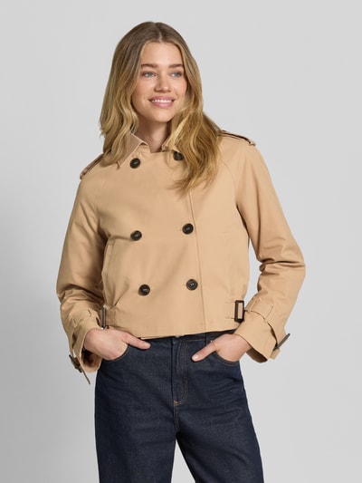 Frauenmodel trägt Trench Jacke mit Eingrifftaschen und Kentkragen von monari in Beige, Gerader-Schnitt, dunkelbraune Knöpfe, Nahaufnahme Oberkörper. Rückenlänge 52 cm, Schulterbreite 47 cm, Brustweite 47 cm, Ärmellänge 57 cm.