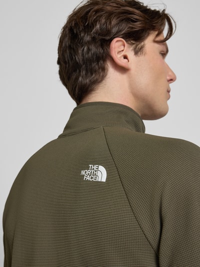 Männermodel trägt Jacke mit Raglanärmeln und Logo-Print Modell 'PACKABLE KECHA' von The North Face in Olivgrün, Material-Mix, Nahaufnahme Rückansicht.