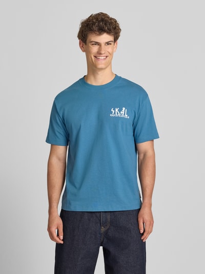 Männermodel trägt Relaxed Fit T-Shirt aus reiner Baumwolle von Marc O'Polo Denim, Optik: Unifarben, Label-Print, Ganzkörperansicht von vorne.