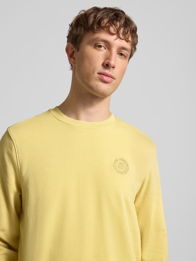 Männermodel trägt Regular Fit Pullover mit Logo-Stitching Modell 'Kane' von Blend in Gelb, Baumwoll-Mix, Nahaufnahme Oberkörper.