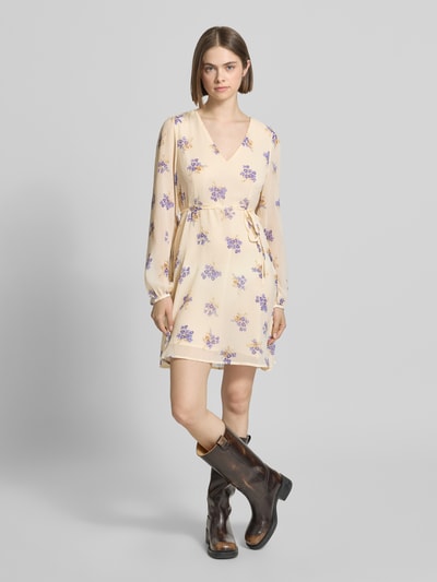 Frauenmodel trägt Minikleid aus Chiffon Modell 'MIRIAM-FUSINA' von Only, Optik: Allover-Muster, florales Muster, Taillengürtel, Mini-Länge, V-Ausschnitt, Langarm mit Ballonärmel und Knopf mit Öse, Chiffon Materialverarbeitung, Ganzkörperansicht von vorne.
