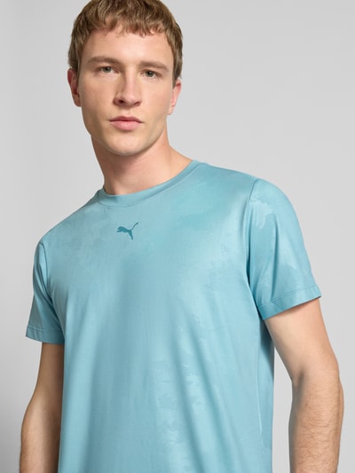 Männermodel trägt T-Shirt mit Label-Detail Modell 'CLOUDSPUN' von PUMA PERFORMANCE, Elastischer-Material-Mix, Gerader-Schnitt, Rundhalsausschnitt, Nahaufnahme Oberkörper. Rückenlänge bei Größe M 63 cm.