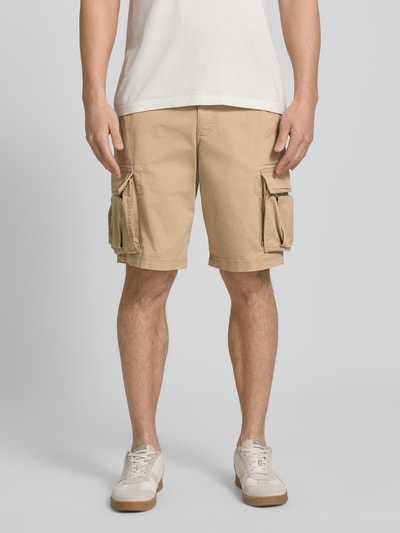 Männermodel trägt Shorts mit Cargotaschen Modell 'NEW 24' von GAP aus Baumwoll-Elasthan-Mix, Regular-Fit, beige, Ganzkörperansicht von vorne.