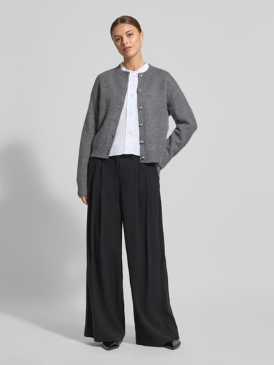 Frauenmodel trägt Regular Fit Hemdbluse aus reiner Baumwolle von Emporio Armani in Weiß, Stehkragen, durchgehende Knopfleiste, Langärmelig, verlängerte Rückseite, Ganzkörperansicht von vorne.