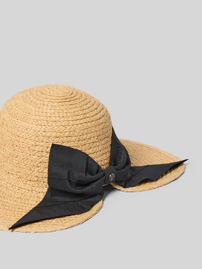 Produktfoto, naturfarbener Hut mit schwarzer Zierschleife Modell 'Raffia' von Loevenich aus Stroh mit Logo-Detail auf grauem Hintergrund.