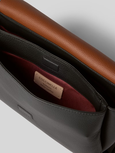 Produktfoto, Shoulder Bag mit Logo-Print Modell 'Grana' von Coccinelle, geteiltes Hauptfach, glattes schwarzes Leder, brauner Überschlag, Innenfutter bordeaux, dezente Logo-Prägung, Damen Shoulder Bag, 28x17x10 cm, abnehmbarer Schulterriemen 130 cm