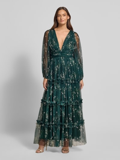 Modelka kobieca ma na sobie Sukienka wieczorowa 'Abendkleid im Stufen-Look mit V-Ausschnitt' od Lace & Beads z zielonego tiulu, linia A, efekt stopniowania, dekolt w serek, tasiemka w talii, długość tyłu w rozmiarze S: 120 cm, szerokość w rozmiarze S: 38 cm; całkowity widok z przodu.