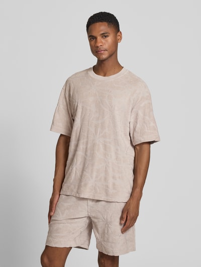 Männermodel trägt Regular Fit T-Shirt aus Baumwoll-Mix Modell 'TE_FLOWER' von BOSS Orange, Allover-Muster, Rundhals, Ganzkörperansicht von vorne.