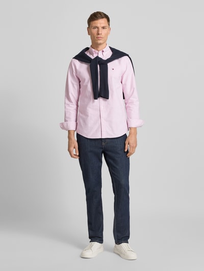 Männermodel trägt Regular Fit Businesshemd aus reiner Baumwolle von Tommy Hilfiger, Optik:Allover-Muster, gestreift, Ganzkörperansicht von vorne.