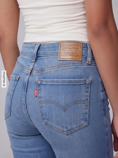 Frauenmodel trägt Slim Fit Bootcut-Jeans aus Baumwoll-Mix mit Lyocell-Anteil Modell '725 HIGH RISE BOOTCUT' von Levi's® 300 in hellem Blau, Damen Bootcut-Jeans von Levi's® 300, Nahaufnahme Rückansicht, KI-modifiziertes Bild.