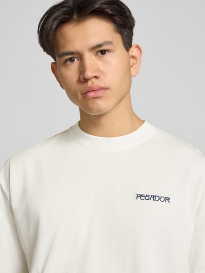 Männermodel trägt Oversized Herren T-Shirt aus Reine Baumwolle von Pegador, Label-Stitching Modell 'Ravello', Nahaufnahme Oberkörper.