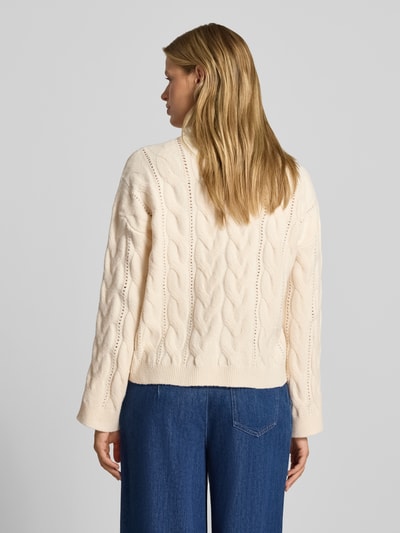 Frauenmodel trägt Relaxed Fit Pullover mit Rundhalsausschnitt Modell 'KATHY' von PIECES, cremefarben mit Zopfmuster, Damen Pullover, Ganzkörperansicht Rückansicht.