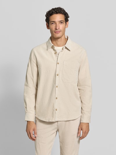 Männermodel trägt Comfort Fit Hemdjacke aus Baumwoll-Mix von s.Oliver RED LABEL in Beige, sichtbar strukturierte Oberfläche, Ganzkörperansicht von vorne.