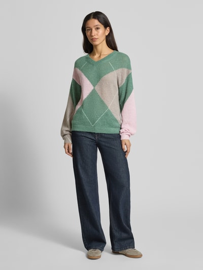 Frauenmodel trägt Wollpullover mit gerippten Abschlüssen von Fynch-Hatton in Grün, Beige und Rosa, Material-Mix mit Woll-Anteil, lockerer Schnitt, V-Ausschnitt, Ganzkörperansicht von vorne.