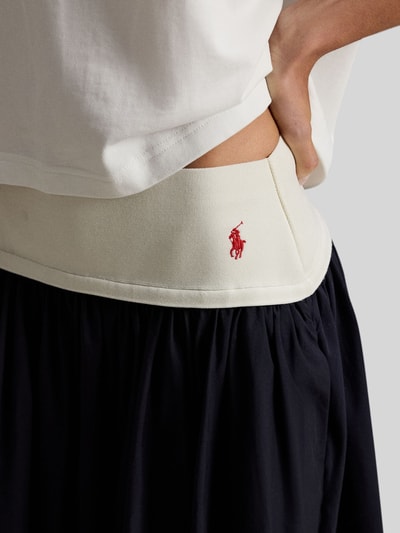 Frauenmodel trägt Ausgestellter Midi-Rock aus reiner Baumwolle von Polo Ralph Lauren in Two Tone Optik mit Logo-Stitching, Nahaufnahme Oberkörper.