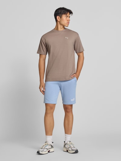 Männermodel trägt Relaxed Fit T-Shirt aus reiner Baumwolle Modell 'ESS ELEVATED' von PUMA, Herren T-Shirt von PUMA Performance, Ganzkörperansicht von vorne.