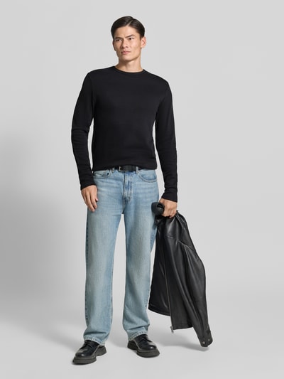 Männermodel trägt Regular Fit Longsleeve aus reiner Baumwolle Modell 'Basic' von Lindbergh, schwarzer Stoff, Ganzkörperansicht von vorne. Rückenlänge bei Größe M: 73 cm, Rundhalsausschnitt.
