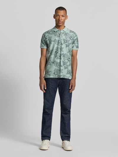Männermodel trägt Slim Fit Poloshirt mit floralem Allover-Print von Lerros in Mintgrün aus Reiner Baumwolle, Polokragen, Kurzärmelig, Ganzkörperansicht von vorne.