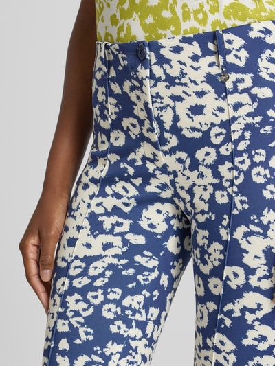 Frauenmodel trägt Regular Fit Hose im Allover-Look von Marc Cain in Blau und Weiß, Material-Mix mit Stretch-Anteil, Nahaufnahme Oberkörper.
