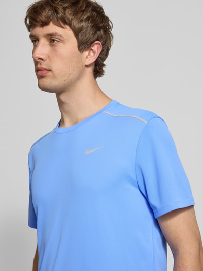 Männermodel trägt T-Shirt mit Rundhalsausschnitt und Logo von NIKE TRAINING in Regular-Fit, Kontraststreifen, hellblau, Nahaufnahme Oberkörper. Rückenlänge bei Größe M: 74 cm.