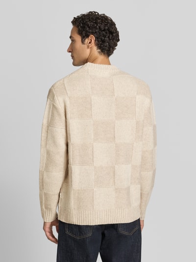 Männermodel trägt Strickpullover mit geripptem Rundhalsausschnitt von Les Deux, beige kariertes Muster, reine Baumwolle, Ganzkörperansicht Rückansicht.