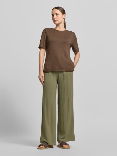 Kobiece modelka nosi spodnie Regular Fit Weite Hose aus Viskose-Leinen-Mix model 'VIVA-GULIA' od Selected Femme, efekt: jednolity kolor, krój regular fit, tunel, elastyczny ściągacz, wpuszczane kieszenie, wykończenie materiału: cieniowana przędza, materiał: mieszanka wiskozy i lnu, szerokie, jasnooliwkowe, gładka tekstura. Ganzkörperansicht von vorne.