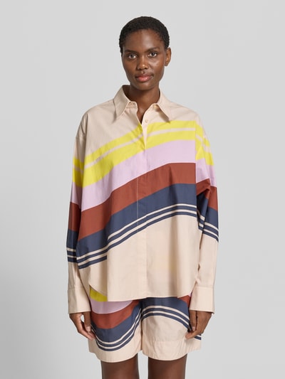 Frauenmodel trägt Boxy Fit Langarmbluse aus reiner Baumwolle Modell 'JOPPY' von Essentiel Antwerp mit bunten Streifen, Ganzkörperansicht von vorne.