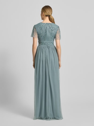 Modelka kobieca ma na sobie sukienkę wieczorową 'Abendkleid mit Ziersteinbesatz' od Christian Berg Cocktail, linia a, długa sukienka, dekolt w serek, marszczenia, zamek błyskawiczny z tyłu, obszycie ozdobnymi kamieniami, długość tyłu w rozmiarze 36: 140 cm, szerokość w rozmiarze 36: 38 cm, długość rękawów w rozmiarze 36: 21 cm, widok całej sylwetki od tyłu.