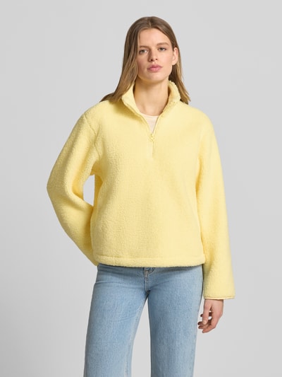 Vrouwenmodel draagt Regular Fit Pullover met opstaande kraag model 'Vera' van JJXX van teddyfleece in lichtgeel, halfhoge rits, Ganzkörperaanzicht van voren.