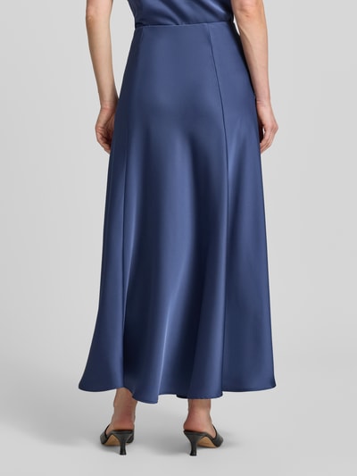 Frauenmodel trägt Maxirock aus Satin mit elastischem Bund von Zero in dunklem Blau, glatte Oberfläche, A-Linienform, Ganzkörperansicht Rückansicht.