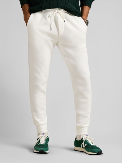 Männermodel trägt Tapered Sweatshorts aus Baumwoll-Mix von Polo Ralph Lauren in Unifarbe mit Logo-Stitching, Nahaufnahme Unterkörper.