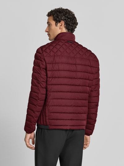 Männermodel trägt Steppjacke mit Stehkragen und Reißverschlusstaschen von Christian Berg Men in Dunkelrot, Rückenansicht, Regular Fit, KI-modifiziertes Bild.