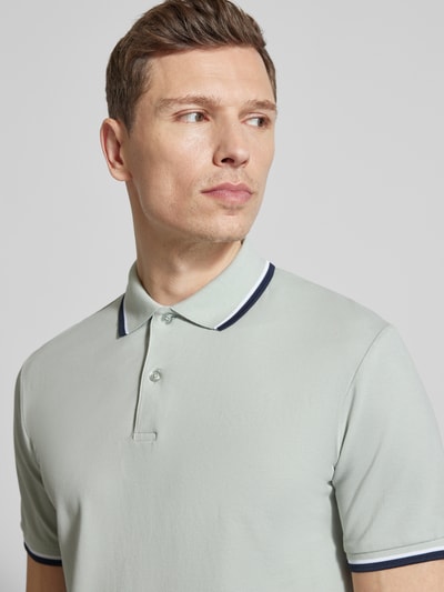 Männermodel trägt Slim Fit Poloshirt aus Bio-Baumwoll-Mix Modell 'SLIM ATLAS SPORT' von SELECTED HOMME in Hellgrün, Nahaufnahme Oberkörper