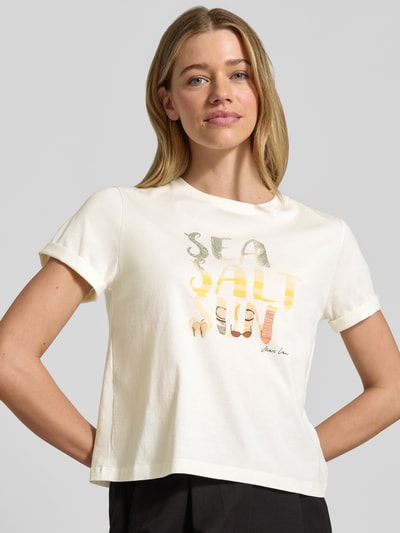 Frauenmodel trägt Damen T-Shirt mit Motiv-Print von Marc Cain in Weiß, Reine Baumwolle, Regular-Fit, Rundhalsausschnitt, Ärmel mit Aufschlag, Rückenlänge bei Größe 36: 51 cm, Nahaufnahme Oberkörper.