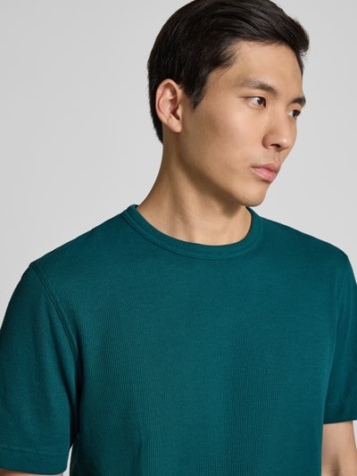 Männermodel trägt Regular Fit T-Shirt aus Baumwoll-Mix von Tom Tailor, unifarben, Piqué-Struktur, Label Patch, Nahaufnahme Oberkörper