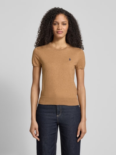 Vrouwenmodel draagt Regular Fit Kurzarmpullover aus Baumwoll-Mix van Polo Ralph Lauren in lichtbruin met logo-stitching, ronde hals, elastische boorden, gemaakt van elastische katoenmix, regular fit. Volledig lichaamsaanzicht van voren.
