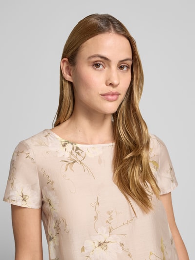 Frauenmodel trägt Blusenshirt mit Rundhalsausschnitt und abgerundetem Saum von Rinascimento, Lyocell-Mix, hell mit Blumenmuster, Loose Fit, Nahaufnahme Oberkörper.