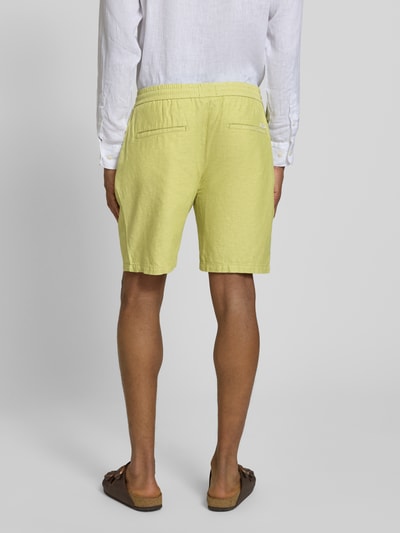 Männermodel trägt Shorts mit elastischem Bund von Scotch & Soda, mieszanka bawełny i lnu, krój regular fit, tunel, szerokość w rozmiarze 32: 43 cm, długość wewnętrzna nogawki: 20 cm, widok całej sylwetki z tyłu