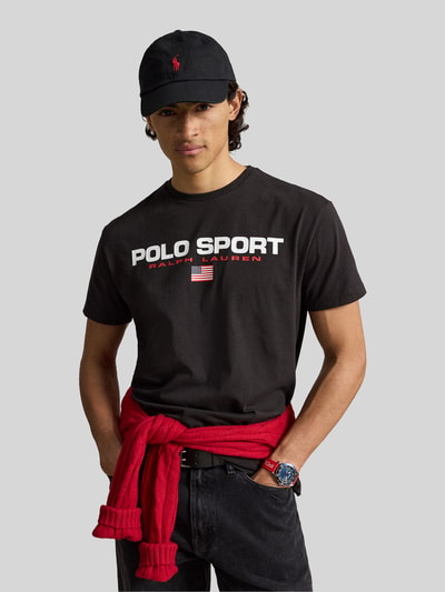 Męskid model nosi Regular Fit T-Shirt aus reiner Baumwolle von Polo Ralph Lauren w kolorze czarnym z białym nadrukiem, Ganzkörperansicht von vorne.