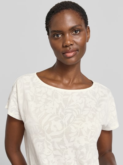 Frauenmodel trägt T-Shirt mit Kordelzug am Saum und Rundhalsausschnitt von Betty Barclay in Offwhite mit floralem Muster, Material-Mix, Nahaufnahme Oberkörper.