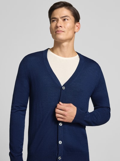 Männermodel trägt Cardigan aus Woll-Mix mit V-Ausschnitt von Christian Berg Men in Dunkelblau, körpernaher Schnitt, Nahaufnahme Oberkörper.