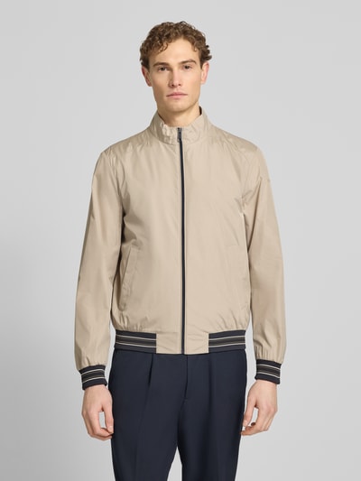 Männermodel trägt Blouson mit Stehkragen und Reißverschluss von Geox in Beige mit Eingrifftaschen, Regular-Fit, Ganzkörperansicht von vorne. Rückenlänge bei Größe M: 68 cm, Schulterbreite: 46 cm, Brustweite: 56 cm, Ärmellänge: 68 cm.