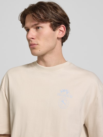 Mężczyznamodel nosi męski t-shirt z bawełny o kroju oversized fit Pegador Oversized T-Shirt mit rückseitigem Print Modell 'Pedroche' z logo-motywem, okrągły dekolt, kontekst: długość tyłu w rozmiarze M: 71 cm; perspektywa: zbliżenie na górną część ciała.
