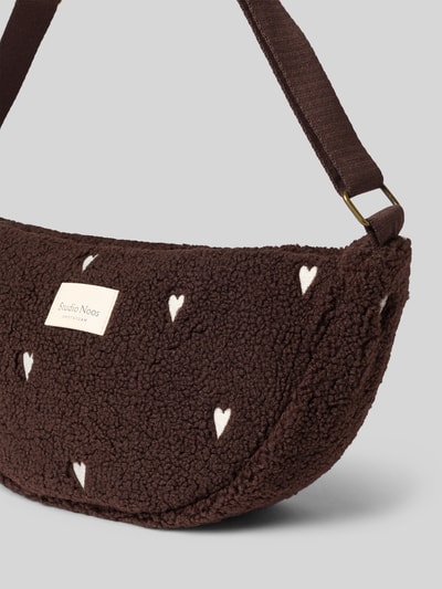 Produktfoto, Bauchtasche aus Teddyfell von Studio Noos w kolorze ciemnobrązowym z wyhaftowanym motywem, główna przegroda z zamkiem błyskawicznym, regulowany pasek na ramię, przegródka wewnętrzna, szerokość w rozmiarze 1: 40 cm, długość w rozmiarze 1: 22 cm, głębokość w rozmiarze 1: 8 cm, długość paska na ramię w rozmiarze 1: 72 cm