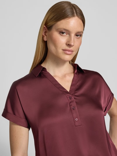 Frauenmodel trägt Regular Fit Bluse mit V-Ausschnitt Modell 'ENNA RAVENNA' von Vila aus Satin mit Knopfleiste, Ärmel mit Aufschlag, Rückenlänge 59 cm bei Größe 36, Nahaufnahme Oberkörper.