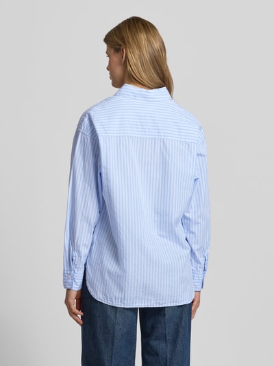 Vrouwenmodel draagt Basic Hemdbluse aus reiner Baumwolle van REVIEW, blauw gestreept, relaxed fit, all-over look, overhemdkraag, knoopsluiting, ruglengte maat S 65 cm, mouwlengte maat S 56 cm. Ganzkörperansicht rugaanzicht.