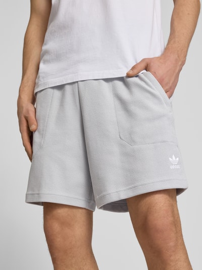 Männermodel trägt Regular Fit Sweatshorts mit Baumwoll-Anteil von adidas Originals, Optik: Unifarben, Waffelstruktur, Logo-Stitching, elastischer Bundabschluss, seitliche Eingrifftaschen, Tunnelzug innen, Nahaufnahme Oberkörper