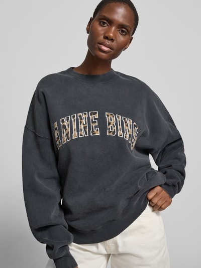 Frauenmodel trägt Oversized Sweatshirt aus Baumwolle von Anine Bing in Dunkelgrau mit Rundhalsausschnitt, elastische Abschlüsse, reine Baumwolle, überschnittene Schultern, Rückenlänge bei Größe S 63 cm, Nahaufnahme Oberkörper.