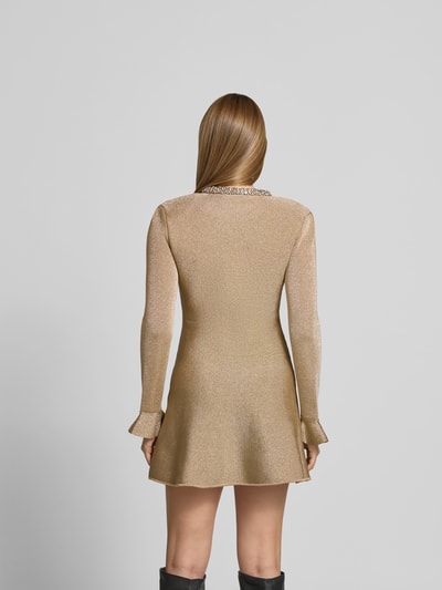 Frauenmodel trägt Minikleid mit Viskose-Anteil von Self-Portrait in Gold, tailliert, Ziersteinbesatz, langarm, Baumwoll-Mix, Ganzkörperansicht Rückansicht.